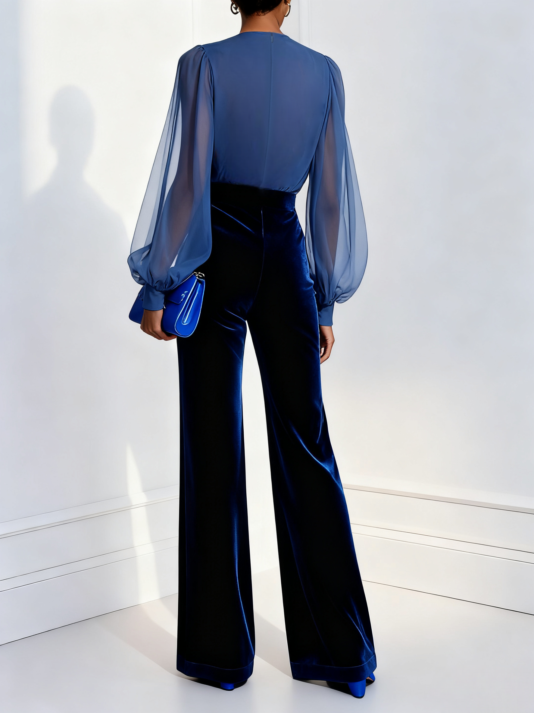 Mono de terciopelo azul con malla, escote en V y mangas largas.